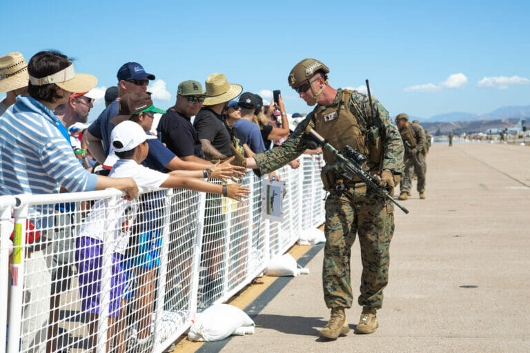 A U.S. Marine with 3rd Battalion, 5th Marine Regiment, 1st Marine Division, interacts with the audience after the Marine Air-Ground Task Force demonstration during the 2022 Marine Corps Air Station Miramar Air Show at MCAS Miramar, San Diego, California, Sept. 24, 2022. The theme for the 2022 MCAS Miramar Air Show, “Marines Fight, Evolve and Win,” reflects the Marine Corps’ ongoing efforts to modernize the force for future conflicts. (U.S. Marine Corps photo by Cpl. Tyler W. Abbott)